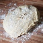 Teig aus Schuessel nehmen und auf bemehlter Arbeitsflaeche bearbeiten