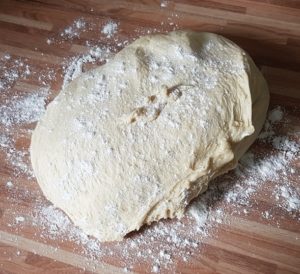 Teig aus Schuessel nehmen und auf bemehlter Arbeitsflaeche bearbeiten