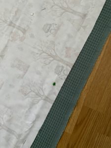 Oberstoff und Unterstoff der Babydecke zusammenstecken und grob zu schneiden