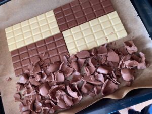 Schokoladentafeln und Schokoladenreste auf Backblech verteilen